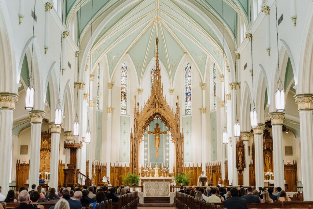 sanctuary and pews of church in frame with stunning altar and crucifix. 